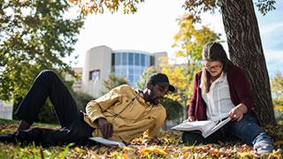 Image of two students studying outside